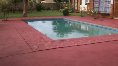 a swimming pool in a yard with a brick driveway at Steenbok Guesthouse in Steenbok