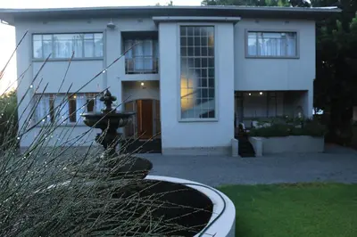 a large white house with a large window at 29onTait Guest House in Pretoria
