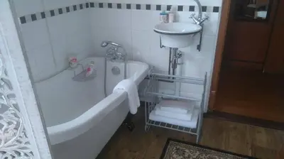 a white bathroom with a tub and a sink at 29onTait Guest House in Pretoria