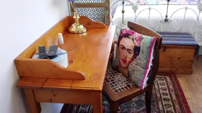 a wooden dining table with a pillow on a chair at 29onTait Guest House in Pretoria
