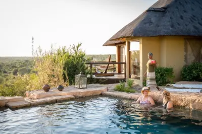 a woman standing in a swimming pool in a house at Makumu Private Game Lodge in Klaserie Private Nature Reserve