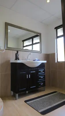 a bathroom with a sink and a mirror at Pensão Guest Lodge in Nelspruit