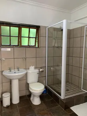 a bathroom with a toilet and a shower and a sink at Pensão Guest Lodge in Nelspruit