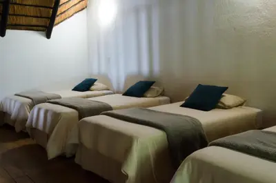 a group of four beds in a room at Pensão Guest Lodge in Nelspruit