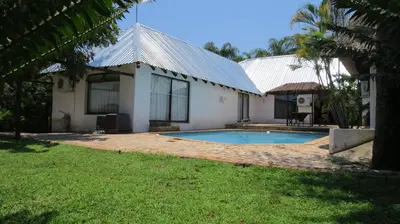 a house with a swimming pool in the yard at Pensão Guest Lodge in Nelspruit