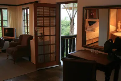 a room with a bedroom with a bed and a balcony at Pensão Guest Lodge in Nelspruit