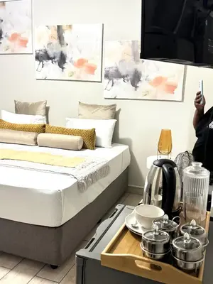 a room with a bed and a tray with pots and pans at Ts Group Africa furnished apartments - Marothwane Saturday Sebola in Pretoria