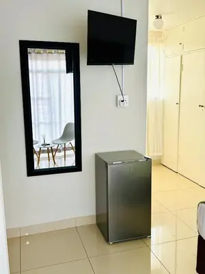 a living room with a mirror and a refrigerator at Ts Group Africa furnished apartments - Marothwane Saturday Sebola in Pretoria