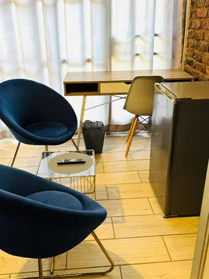 a room with two blue chairs and a desk at Ts Group Africa furnished apartments - Marothwane Saturday Sebola in Pretoria