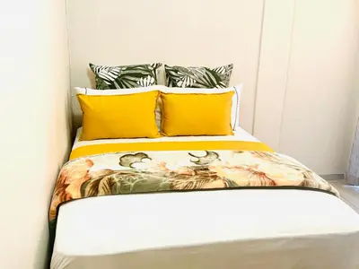 a bedroom with a bed with yellow pillows at Ts Group Africa furnished apartments - Marothwane Saturday Sebola in Pretoria