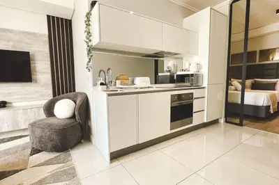 a kitchen with a sink and a chair in a room at Beautiful Galena at Ellipse in Midrand