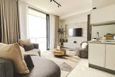 a living room with a couch and a table and a kitchen at Beautiful Galena at Ellipse in Midrand