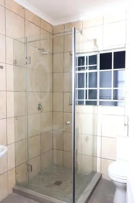 a glass shower in a bathroom with a toilet at Maranzhe Villa in Musina