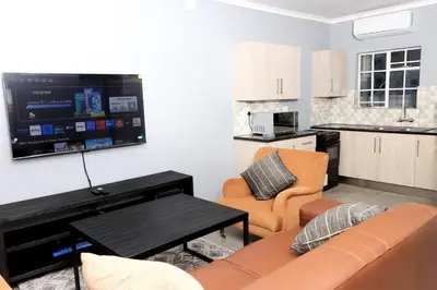 a living room with a couch and a kitchen at Maranzhe Villa in Musina