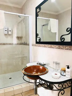 a bathroom with a sink and a shower at Clubview Guest House in Centurion