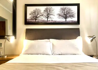 a picture of trees above a bed in a bedroom at Clubview Guest House in Centurion