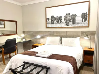 a hotel room with a bed and a picture of elephants at Clubview Guest House in Centurion