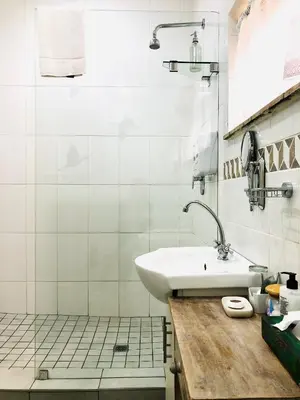 a white bathroom with a sink and a shower at Clubview Guest House in Centurion
