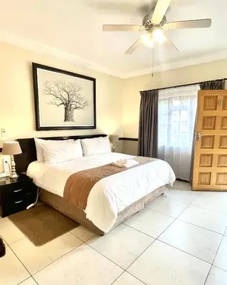 a bedroom with a bed and a ceiling fan at Clubview Guest House in Centurion