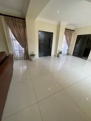 a large living room with a large white tile floor at Villa De Gabe in Monavoni