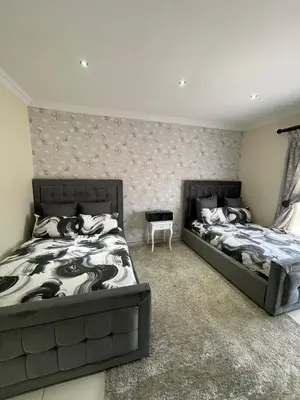 a bedroom with two beds and a table at Villa De Gabe in Monavoni