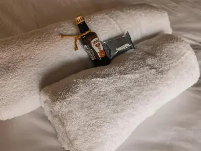a bottle of alcohol sitting on top of towels at Timbila Game Lodge - Welcome to Land of Leopards and Buffalo in Phalaborwa