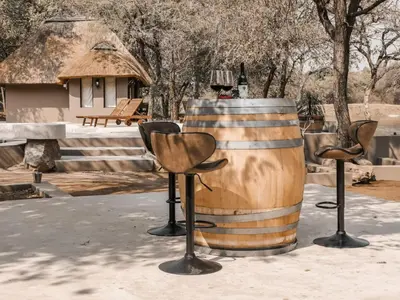 a barrel with two chairs and a lamp on it at Timbila Game Lodge - Welcome to Land of Leopards and Buffalo in Phalaborwa
