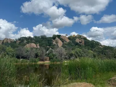 a view of a mountain with rocks and a body of water at Timbila Game Lodge - Welcome to Land of Leopards and Buffalo in Phalaborwa