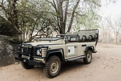 a white jeep parked on a dirt road at Timbila Game Lodge - Welcome to Land of Leopards and Buffalo in Phalaborwa