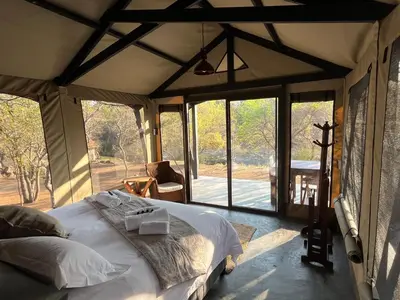 a bedroom with a large bed in a tent at Timbila Game Lodge - Welcome to Land of Leopards and Buffalo in Phalaborwa