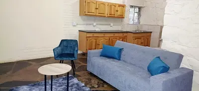 a blue couch and two chairs in a kitchen at Risima Guest Lodge Hazyview in Numbi