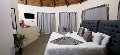 a bedroom with a white bed with white pillows at Risima Guest Lodge Hazyview in Numbi