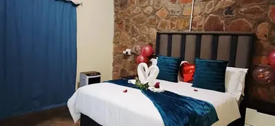 a bedroom with a bed with red balloons on it at Risima Guest Lodge Hazyview in Numbi
