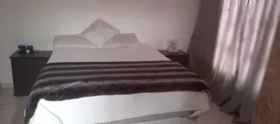 a bedroom with a bed with a brown and white blanket at View in in Nelspruit