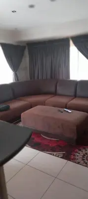 a living room with a brown couch and a table at View in in Nelspruit