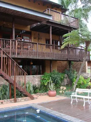 a large house with a deck and a swimming pool at Hennie's Rest in Malelane