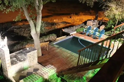 a swimming pool with chairs on a wooden deck at Hennie's Rest in Malelane