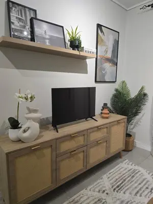 a television on a wooden cabinet in a living room at The River-view in Midrand