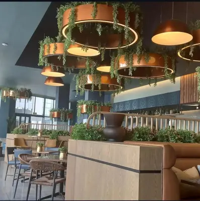 a restaurant with tables and chairs and chandeliers at The River-view in Midrand