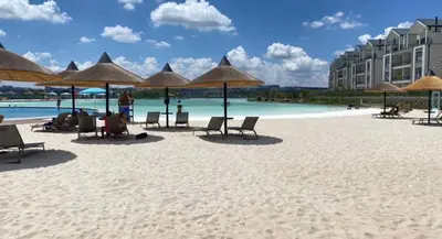 a beach with chairs and umbrellas on the sand at The River-view in Midrand