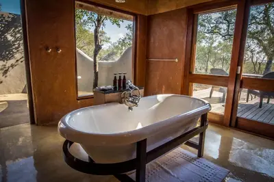 a white tub in a room with a window at Garonga Safari in Makalali Game Reserve