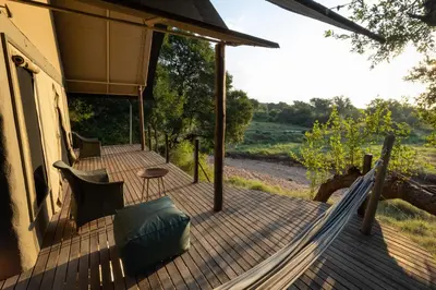 a wooden porch with a hammock on a house at Garonga Safari in Makalali Game Reserve