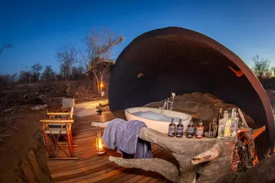 a bathroom with a bath tub on a wooden deck at Garonga Safari in Makalali Game Reserve