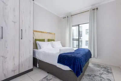 a bedroom with a bed and a large window at Smartz Apartment in Erand