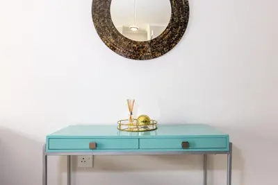 a blue table with a mirror on a wall at Smartz Apartment in Erand