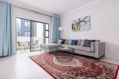 a living room with a couch and a table at Smartz Apartment in Erand