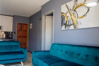 a living room with a couch and a chair at Time Oon-Travel & Tour Equestria Parkview in Pretoria