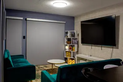 a living room with a couch and a flat screen tv at Time Oon-Travel & Tour Equestria Parkview in Pretoria