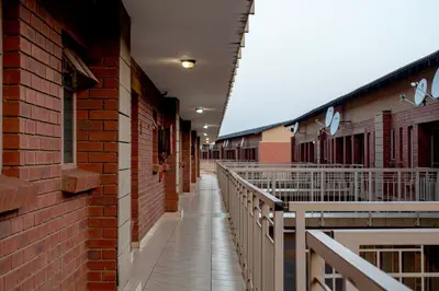 an empty hallway of a brick building with a walkway at Time Oon-Travel & Tour Equestria Parkview in Pretoria