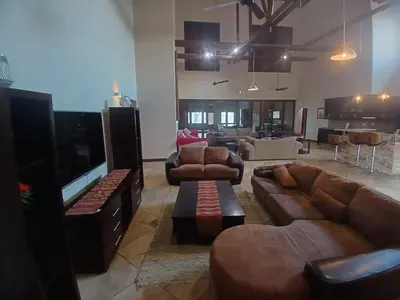 a living room with couches and a flat screen tv at Zebula Golf and Wildlife Estate - Bushveld Bliss Pax 14 - Moi Signature Luxury villa in Mabula